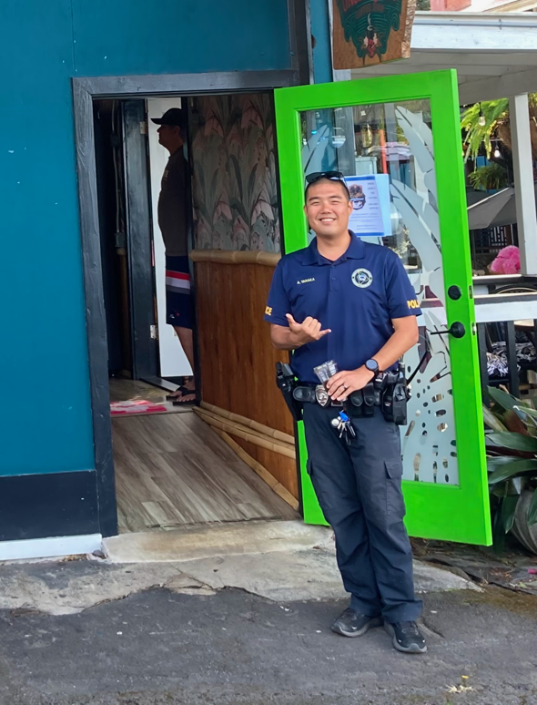 Police Officer Tanaka giving a shaka at front door to Uncle Kimo's coffee.