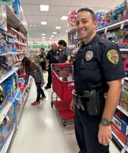 Officer smiling with family picking out toys during Heroes and Helpers event at Target.