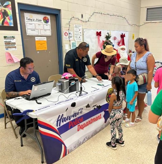 Officers at a booth helping little kids