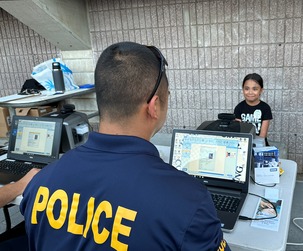 Police officer at a screen creating a keiki id for a young girl